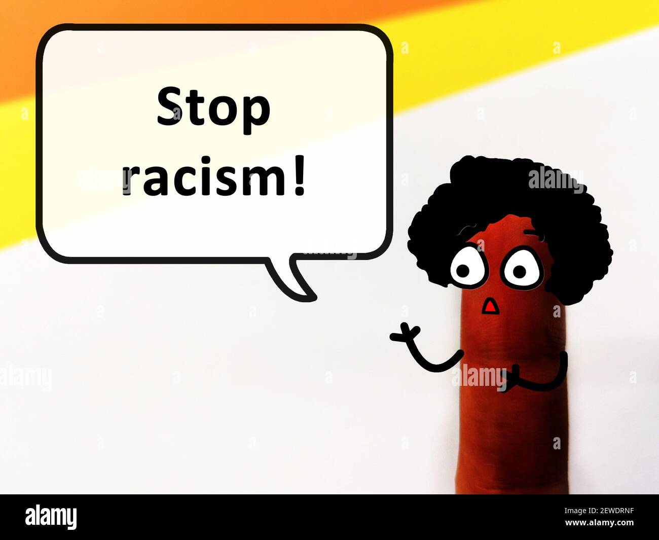 One finger is decorated as a person with dark skin tone. The person is asking to stop racism. Stock Photo