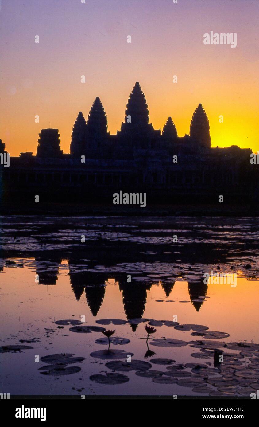 The iconic towers of Angkor Wat reflected in a pond at sunrise. Angkor