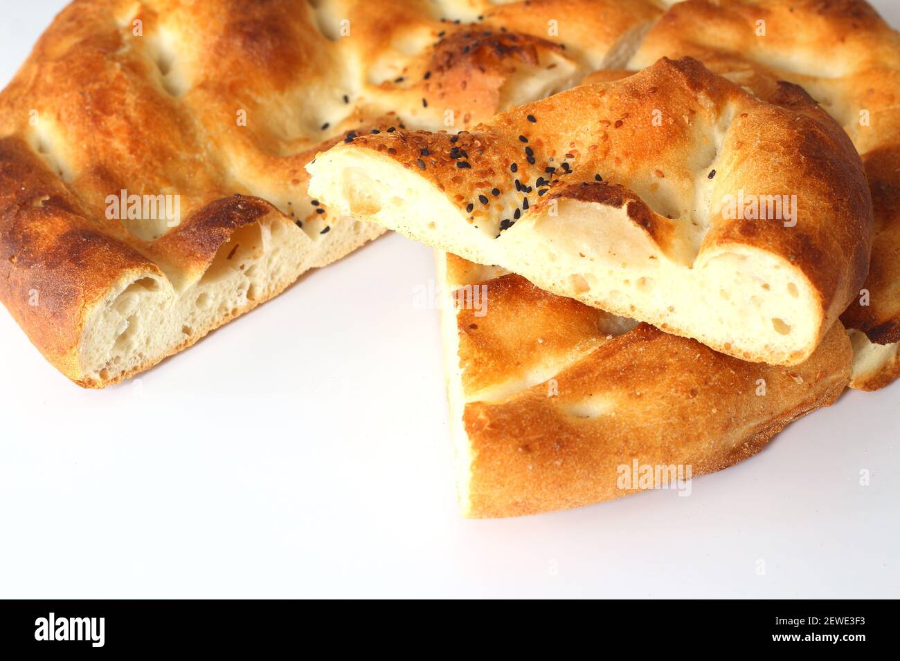 Slices of Ramadan Pita (Ramazan Pidesi) Traditional Turkish bread for holy month Ramadan on white background. Ramadan concept. Stock Photo