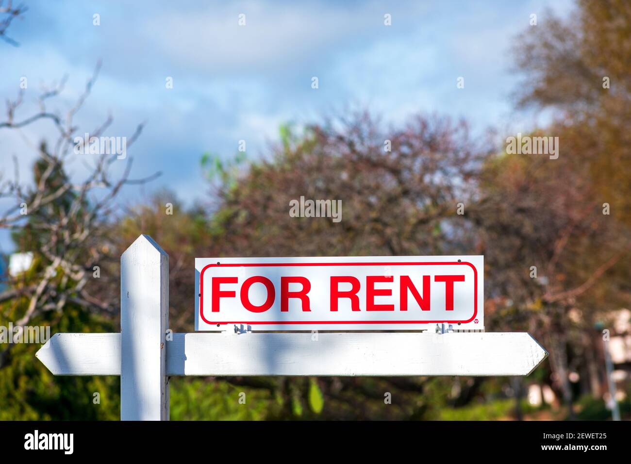For Rent real estate sign. Blurred sky and trees background Stock Photo