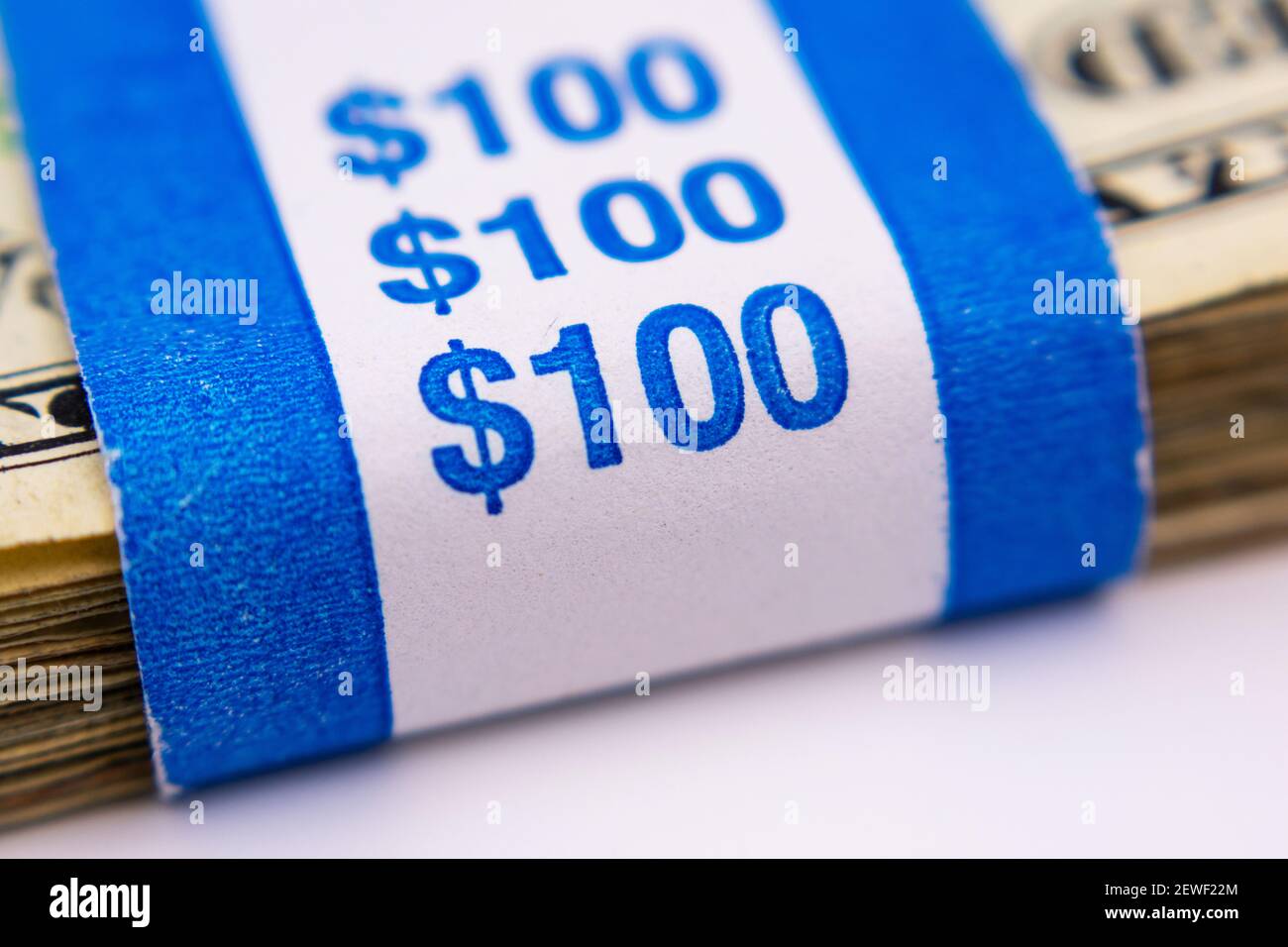100 dollars paper currency strap over stack of United States money. Selective focus. Stock Photo