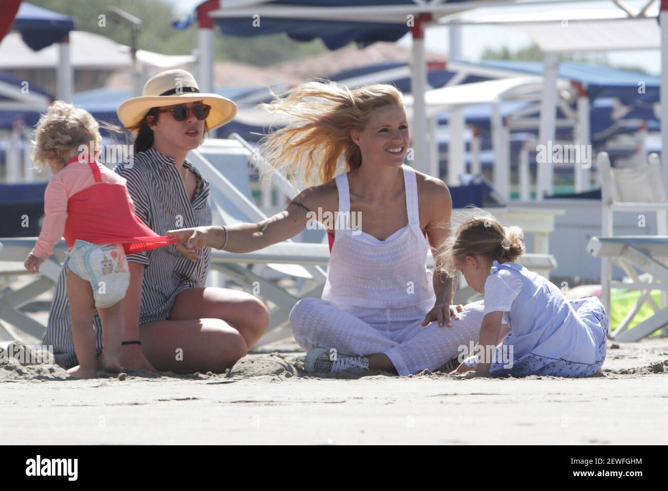 Model Michelle Hunziker plays with her daughters on the beach of Forte