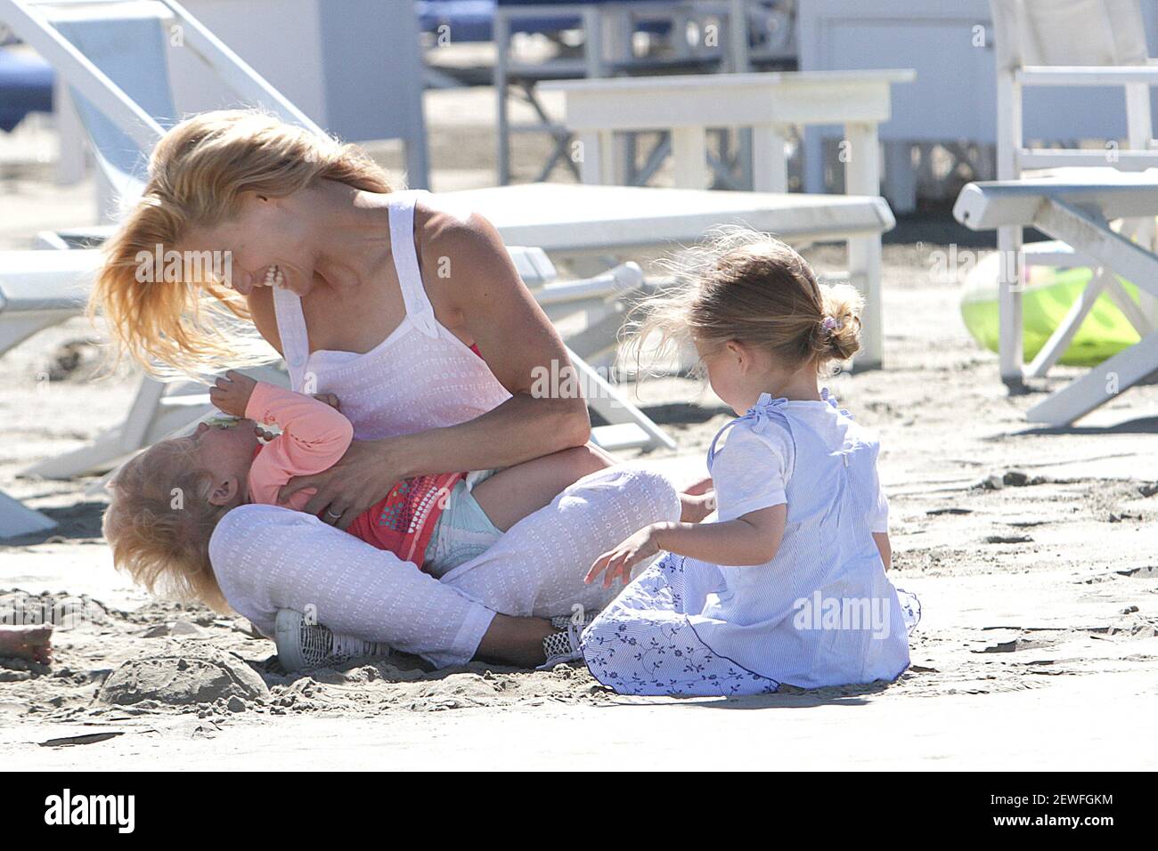 Model Michelle Hunziker plays with her daughters on the beach of Forte