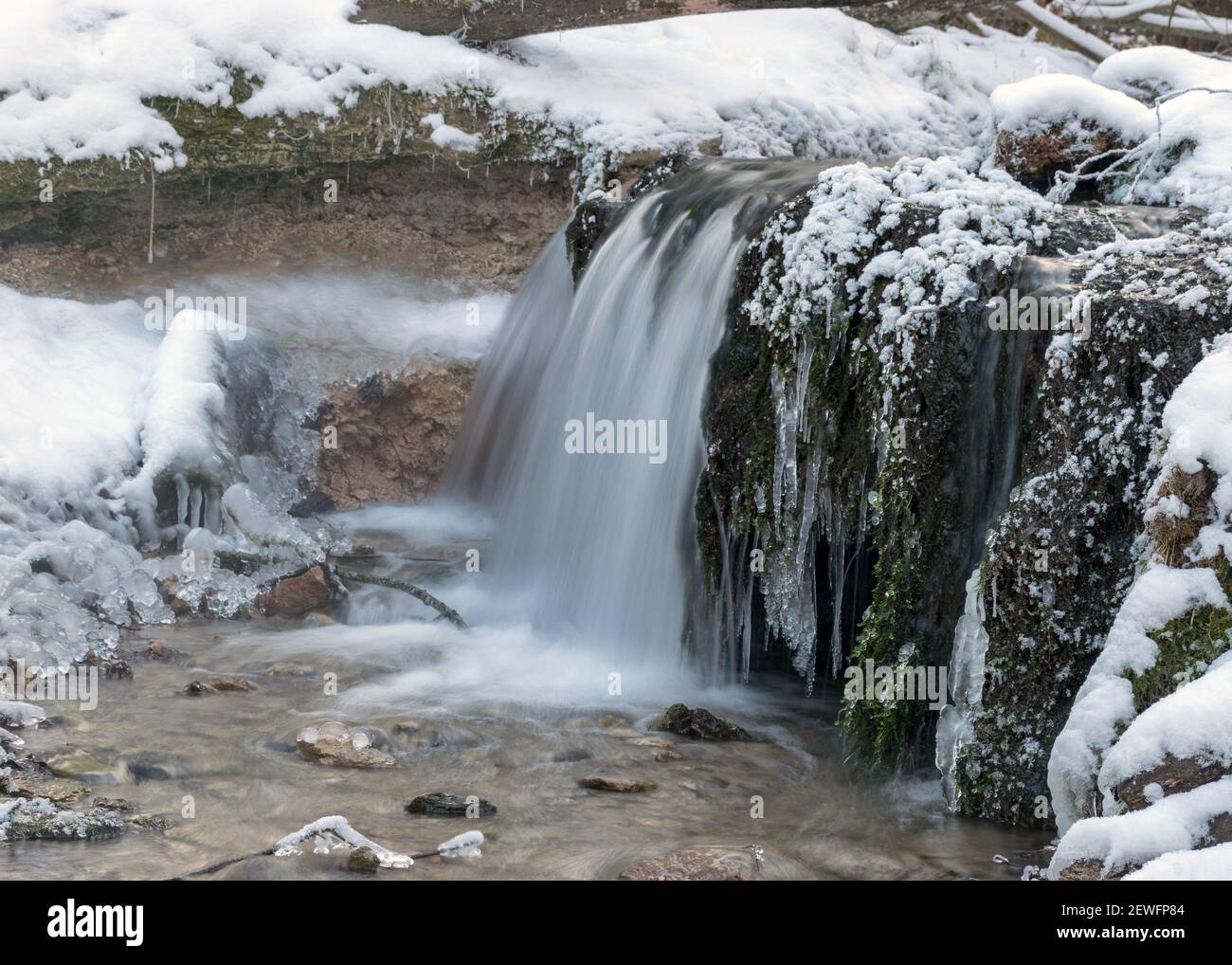 winter landscape with a small waterfall and flooded water, frozen ...