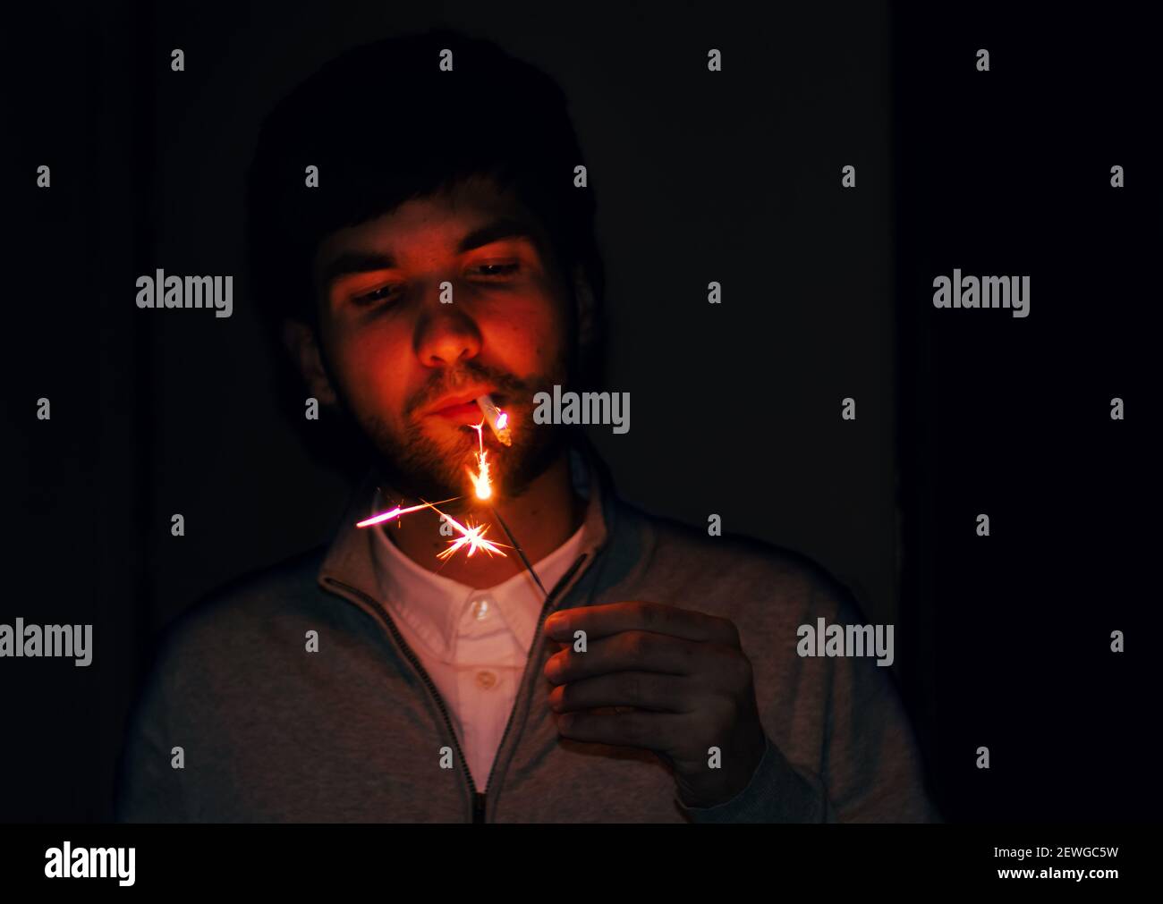a young man lighting a cigarette Stock Photo