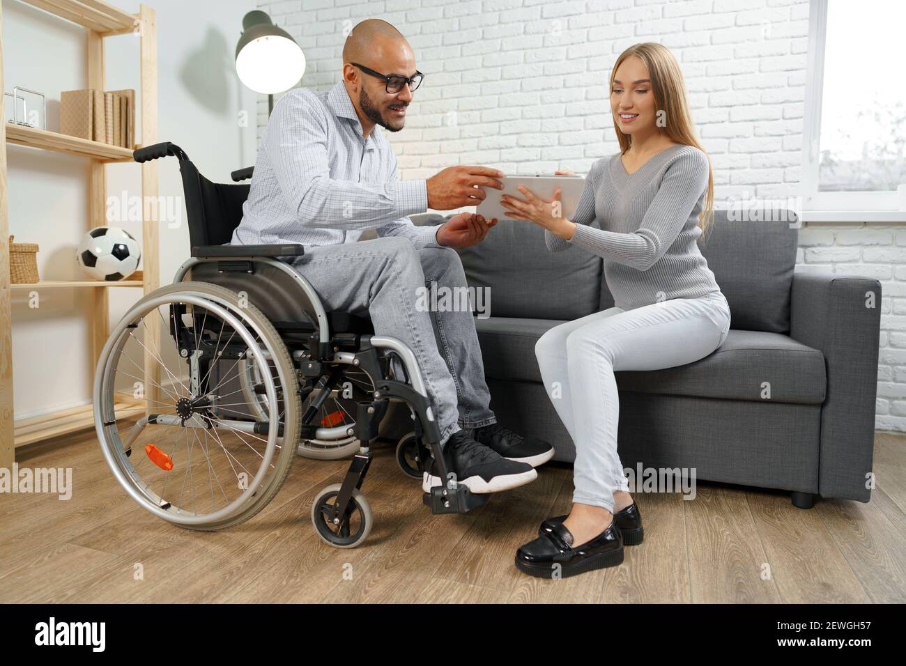 Disabled african american man in wheelchair and his pregnant caucasian