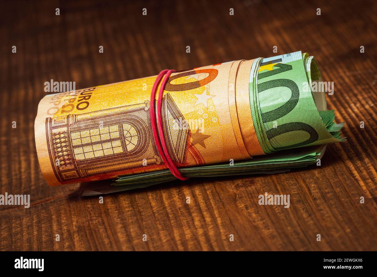 Roll of euro currency banknotes with a rubber band Stock Photo Alamy