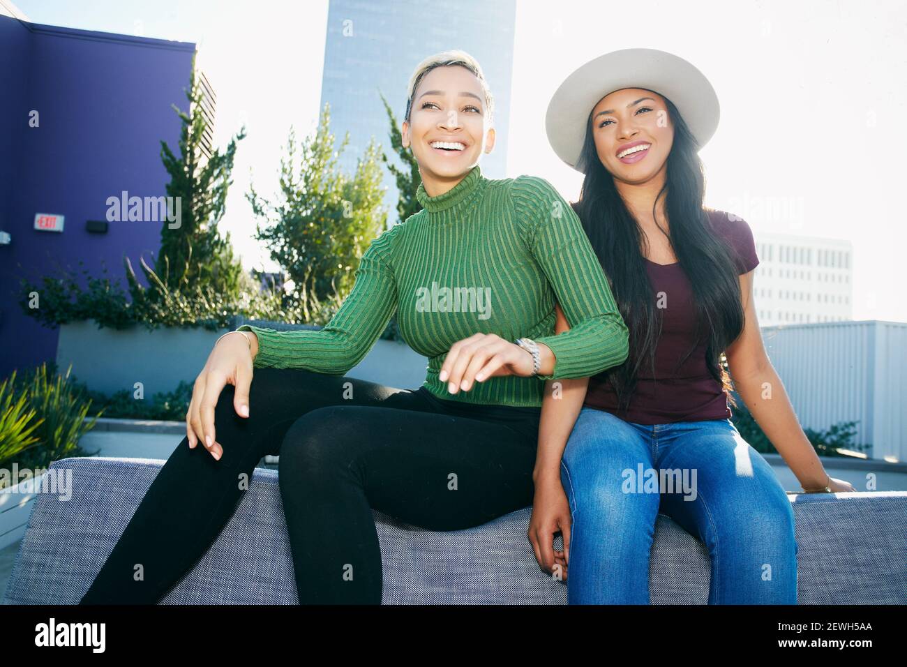Two young women on a rooftop posing for photographs Stock Photo - Alamy