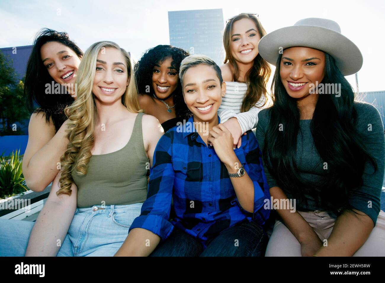 A group of young women partying on a city rooftop at dusk Stock Photo