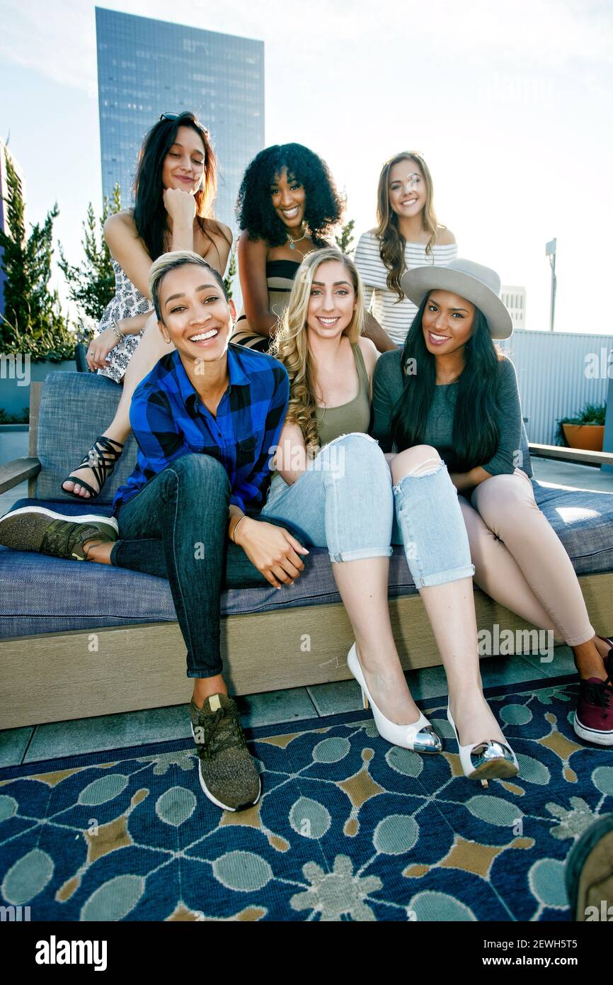 A group of young women partying on a city rooftop at dusk Stock Photo