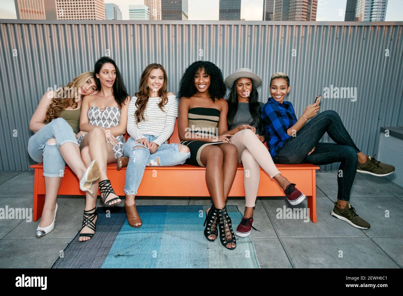 A group of young women partying on a city rooftop at dusk Stock Photo