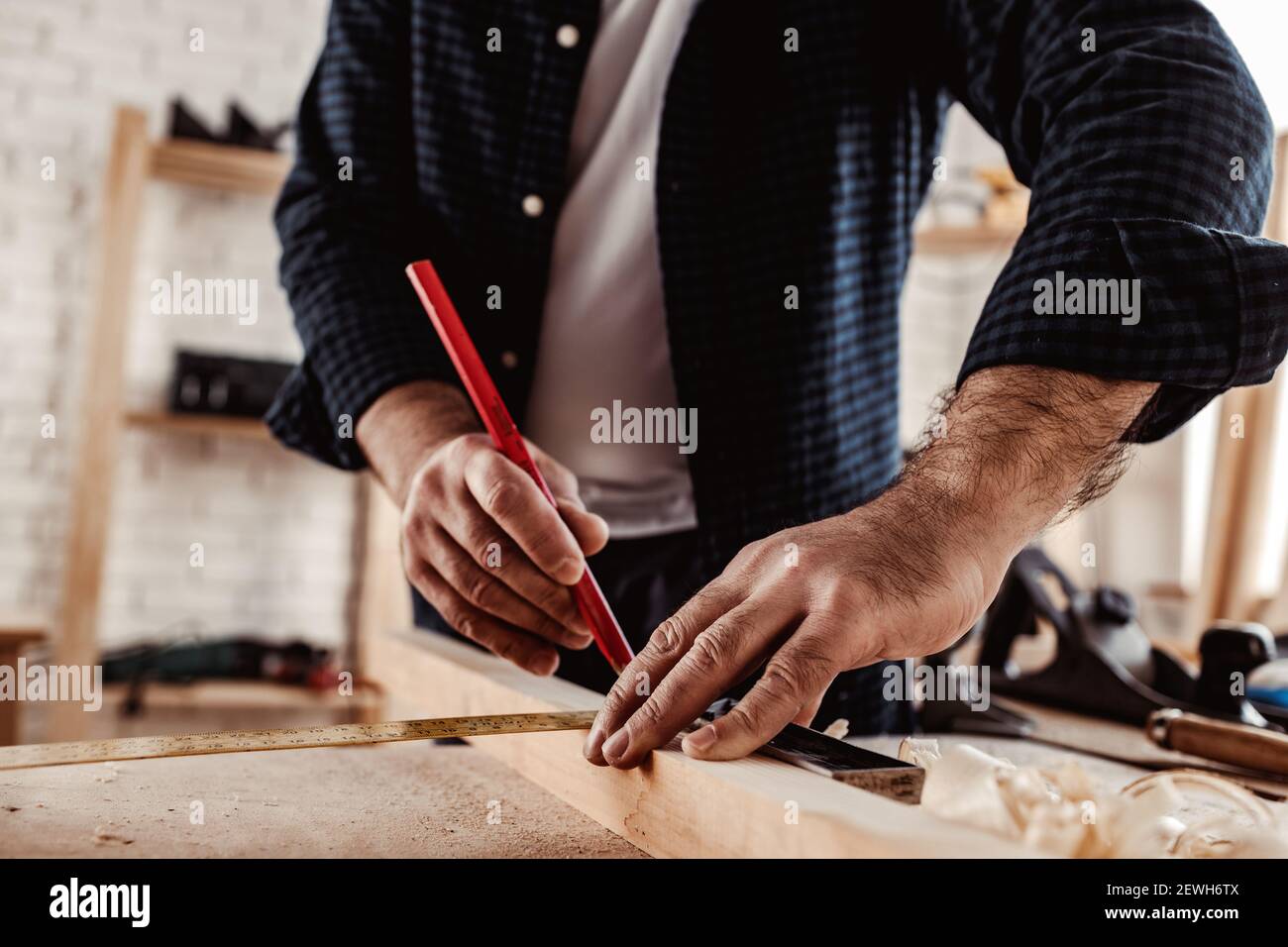 Carpenter makes pencil marks on a wood plank Stock Photo Alamy