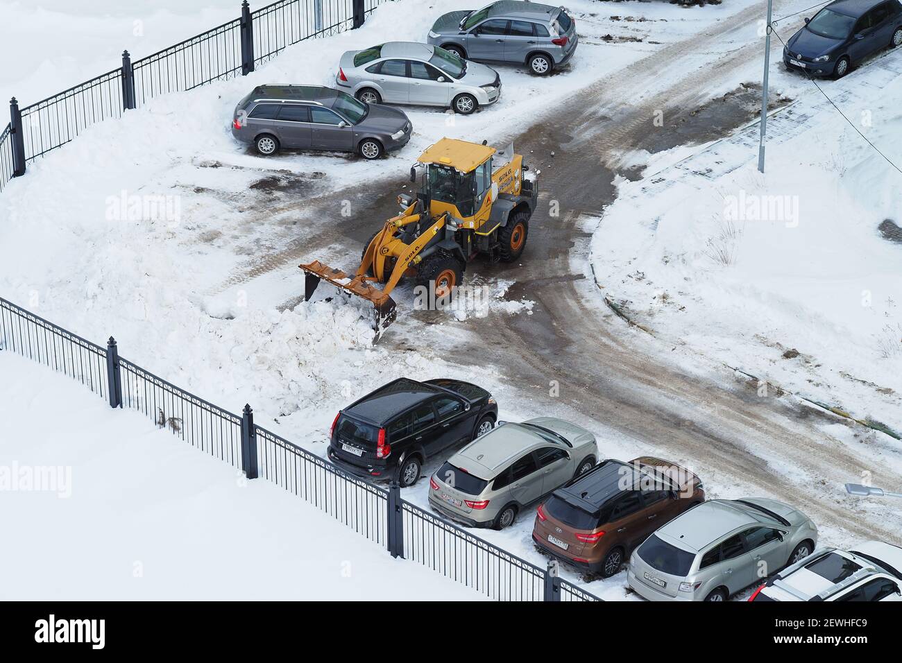 Snow removal equipment. Cleaning of streets and yards from snow. A dump truck loads snow into a