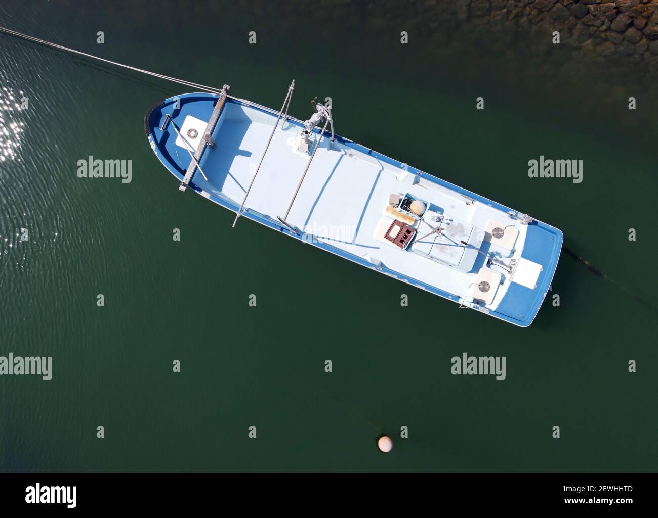 Aerial view of fishing boat moored against a background of deep green sea water Stock Photo