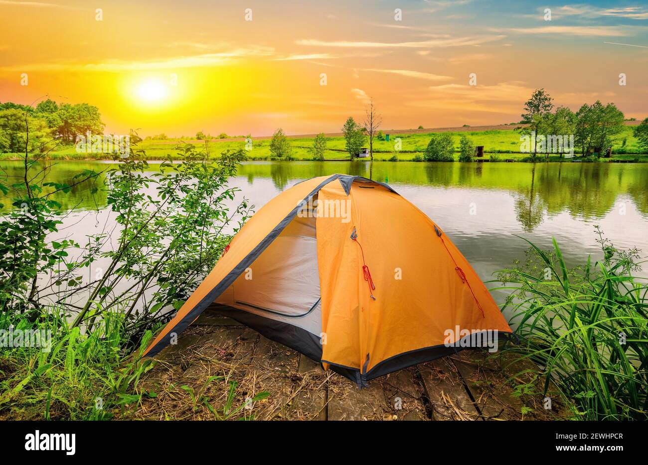 Tent and calm river in the morning. Stock Photo