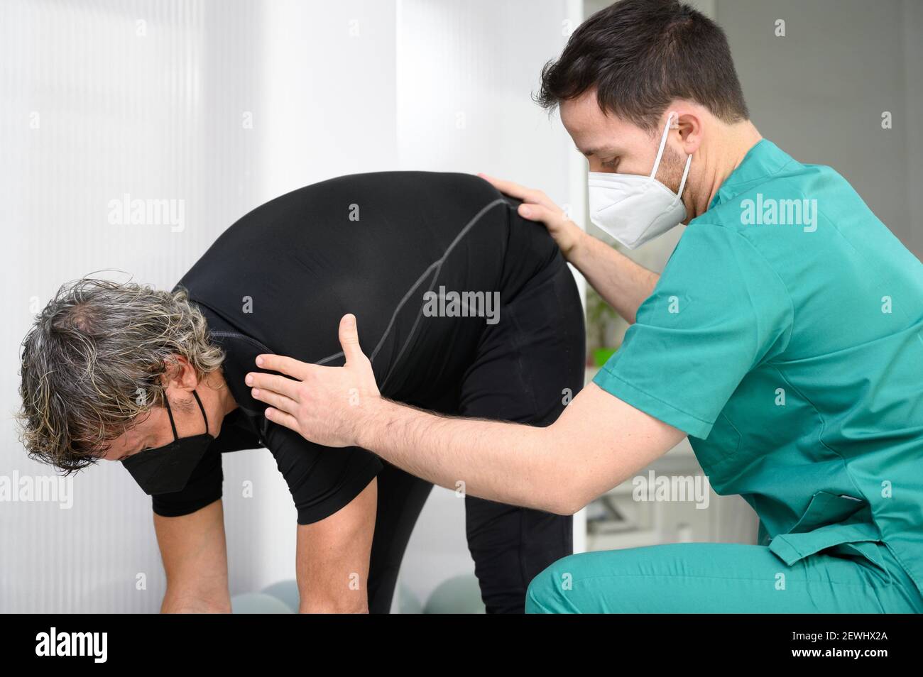 Physiotherapist helping patient in clinic. High quality photo. Stock Photo