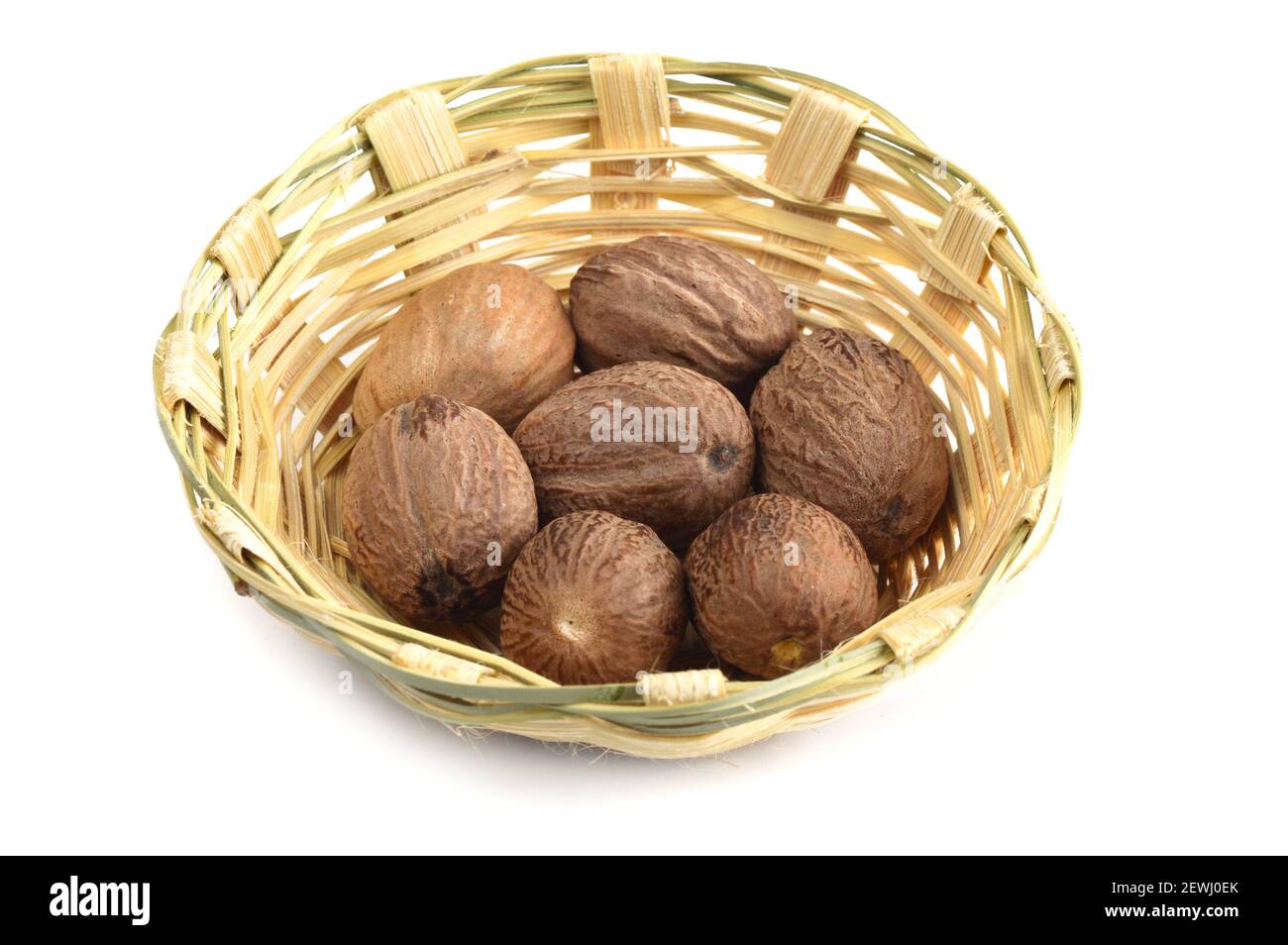 Nutmeg in bamboo basket isolated on white background Stock Photo Alamy