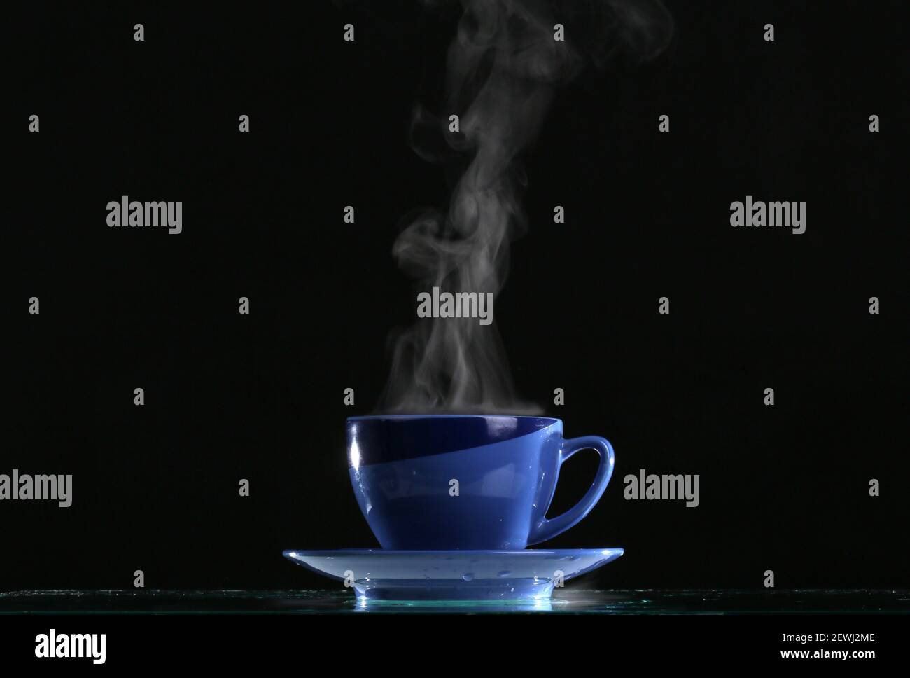Pouring hot water into into a cup on a black background, Stock image
