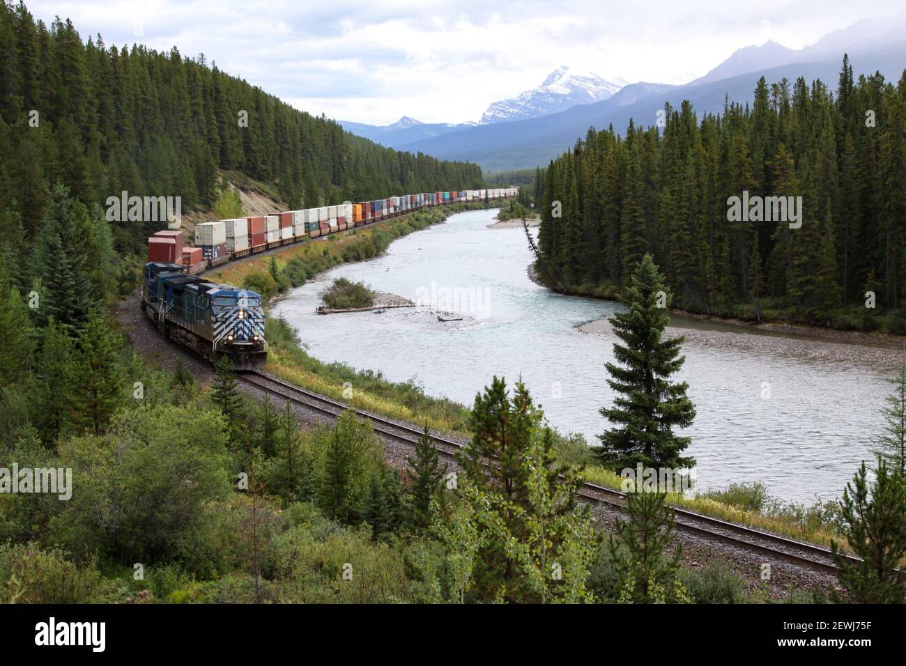 Long train with many cars in Rocky Mountains. Stock Photo