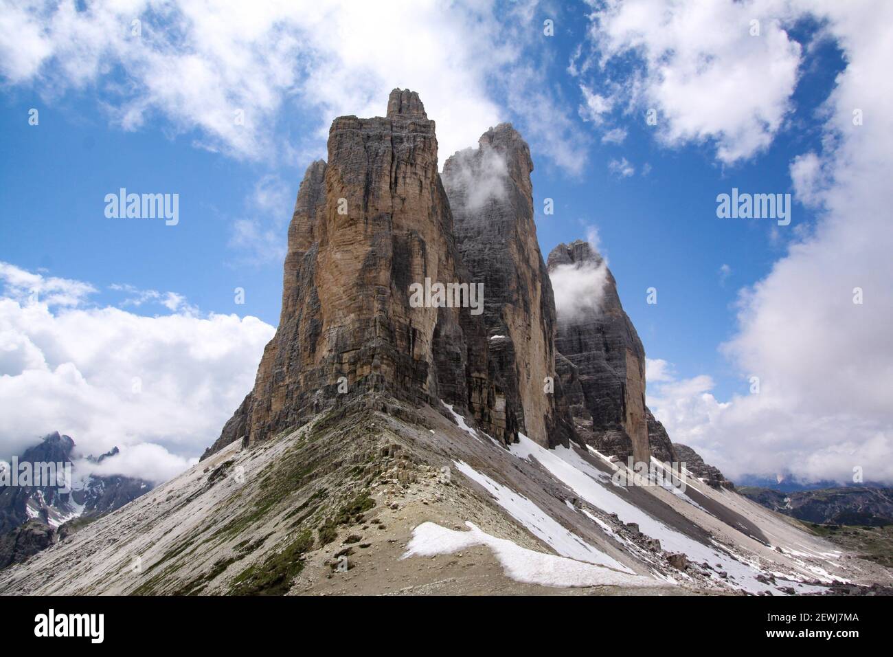 Mountain stock in Dolomites with rock towers as a summit in front of blue sky. Stock Photo