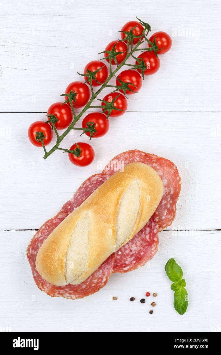 Sub sandwich with salami portrait format from above on wooden board wood. Stock Photo