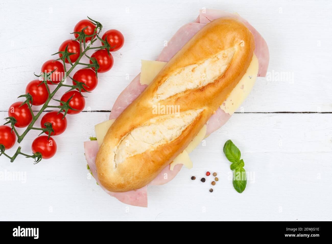 Sub sandwich baguette with ham and cheese from above on wooden board wood. Stock Photo