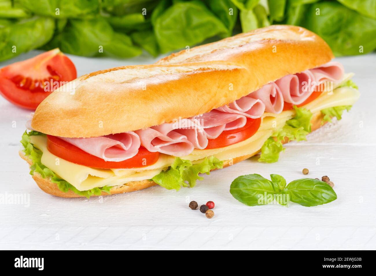 Sub sandwich baguette with ham and cheese on wooden board wood. Stock Photo