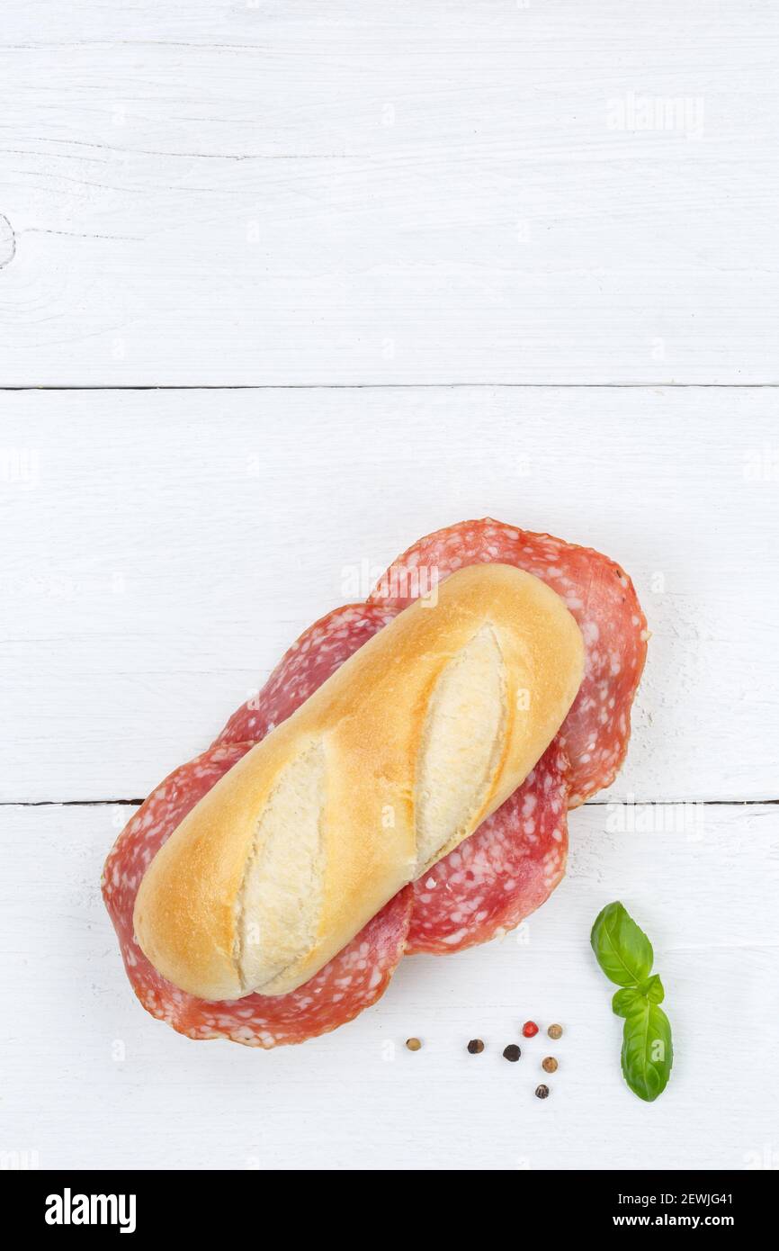 Sub sandwich with salami portrait format copyspace copy space from above on wooden board wood. Stock Photo