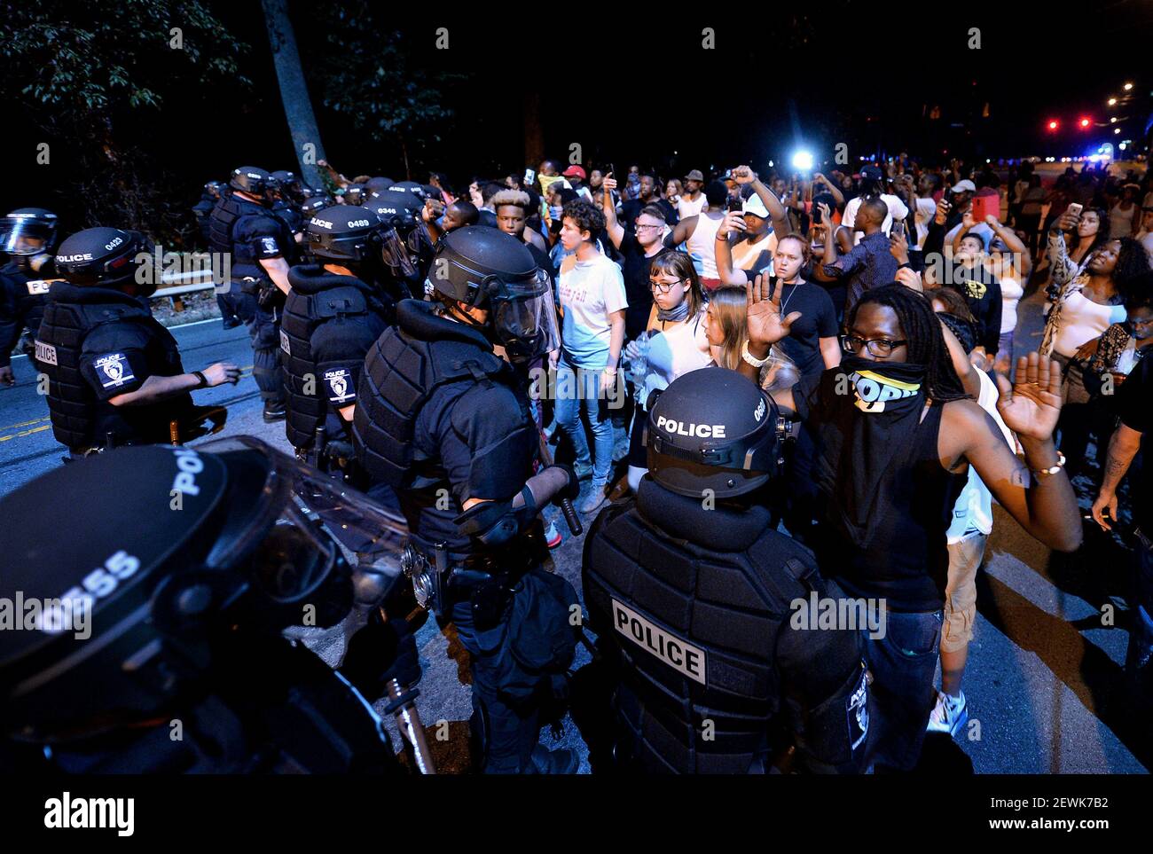 Charlotte-Mecklenburg police officers in riot gear form a line as ...