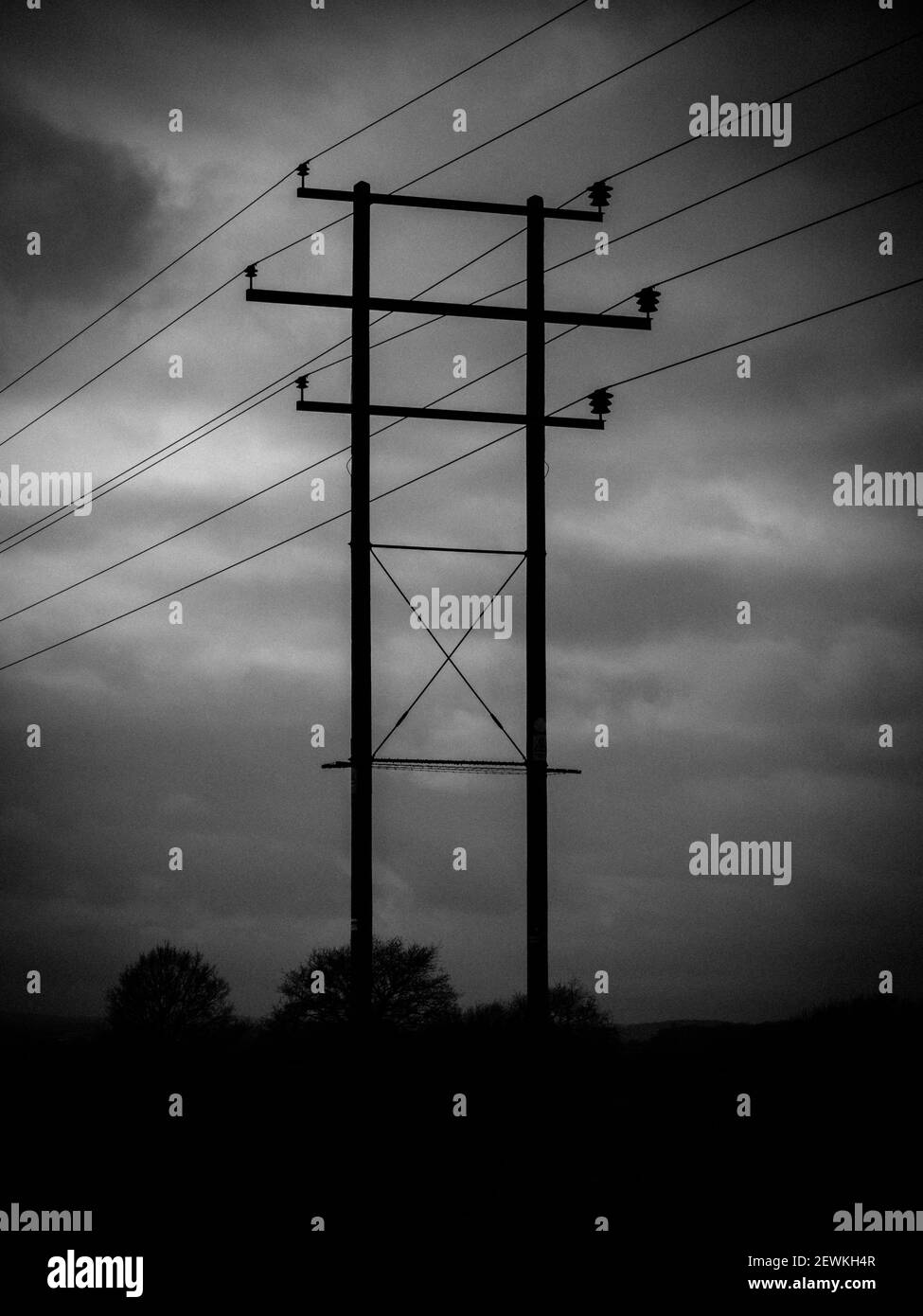 A very moody photograph of a telegraph pole with insulators and cables. Stock Photo