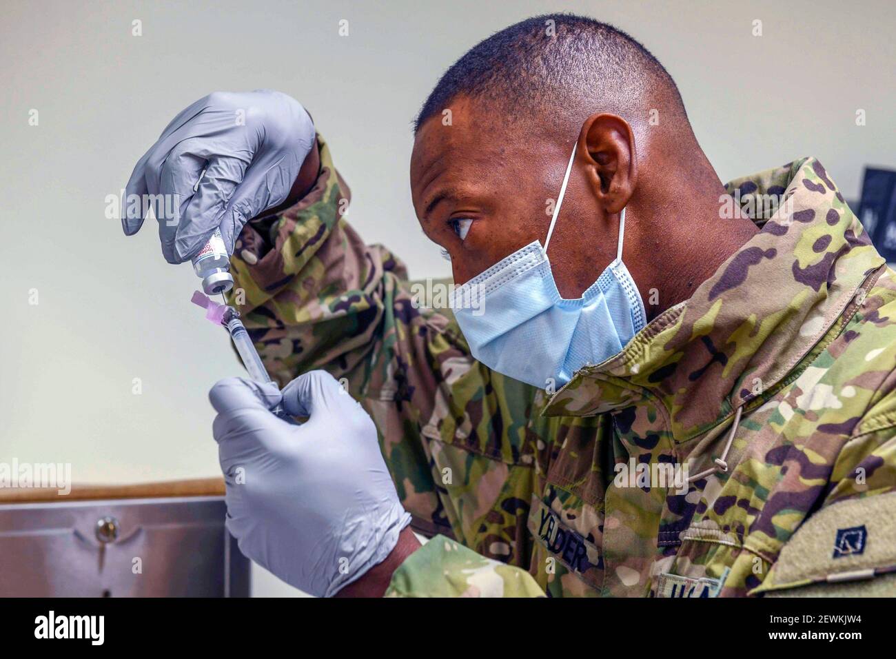 210119-N-ZU710-0137 CHINHAE, Republic of Korea (Jan. 19, 2021) Sgt. Adrian Yelder fills a syringe with a dose of a COVID-19 vaccine at Navy Branch Stock Photo
