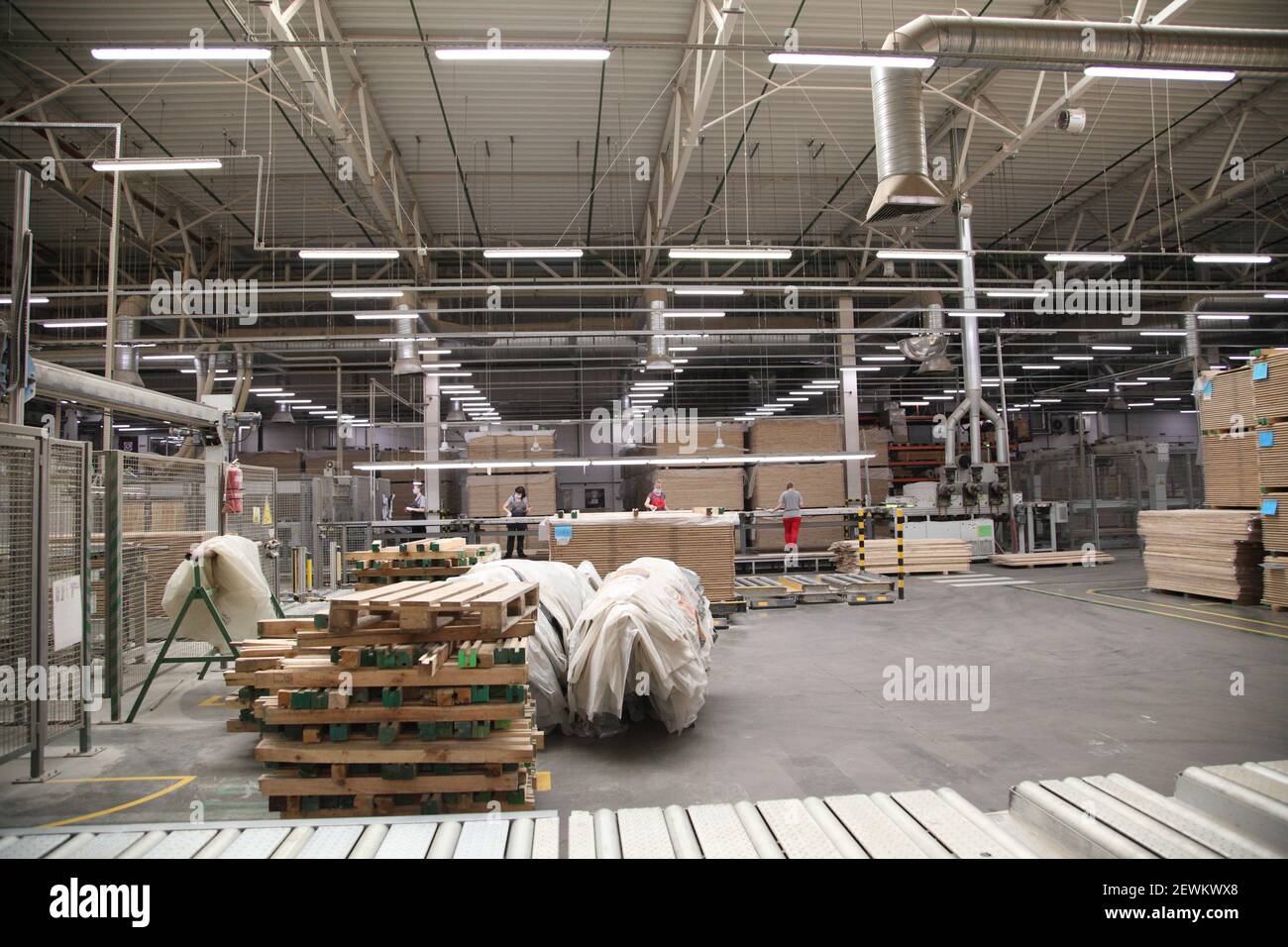 Industrial equipment for the production of laminate. Furniture factory production line. Laminated flooring.The factory for the production of laminate. Stock Photo