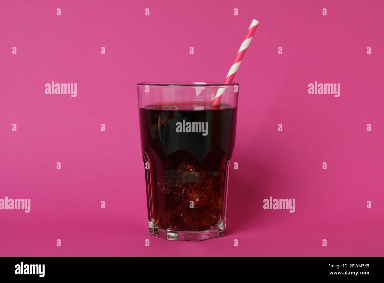Glass of cola with ice cubes and straw on pink background Stock Photo ...