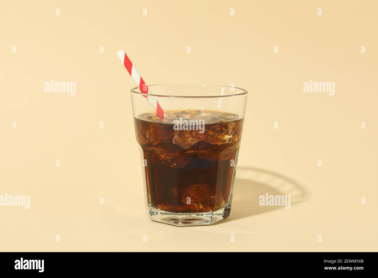 Glass of cola with ice cubes and straw on beige background Stock Photo ...