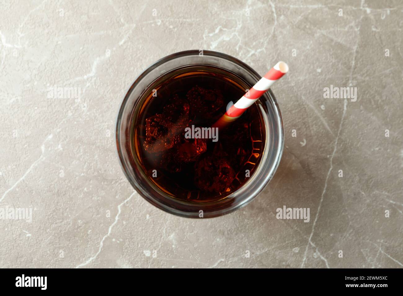 Glass of cola with ice cubes and straw on gray table Stock Photo - Alamy