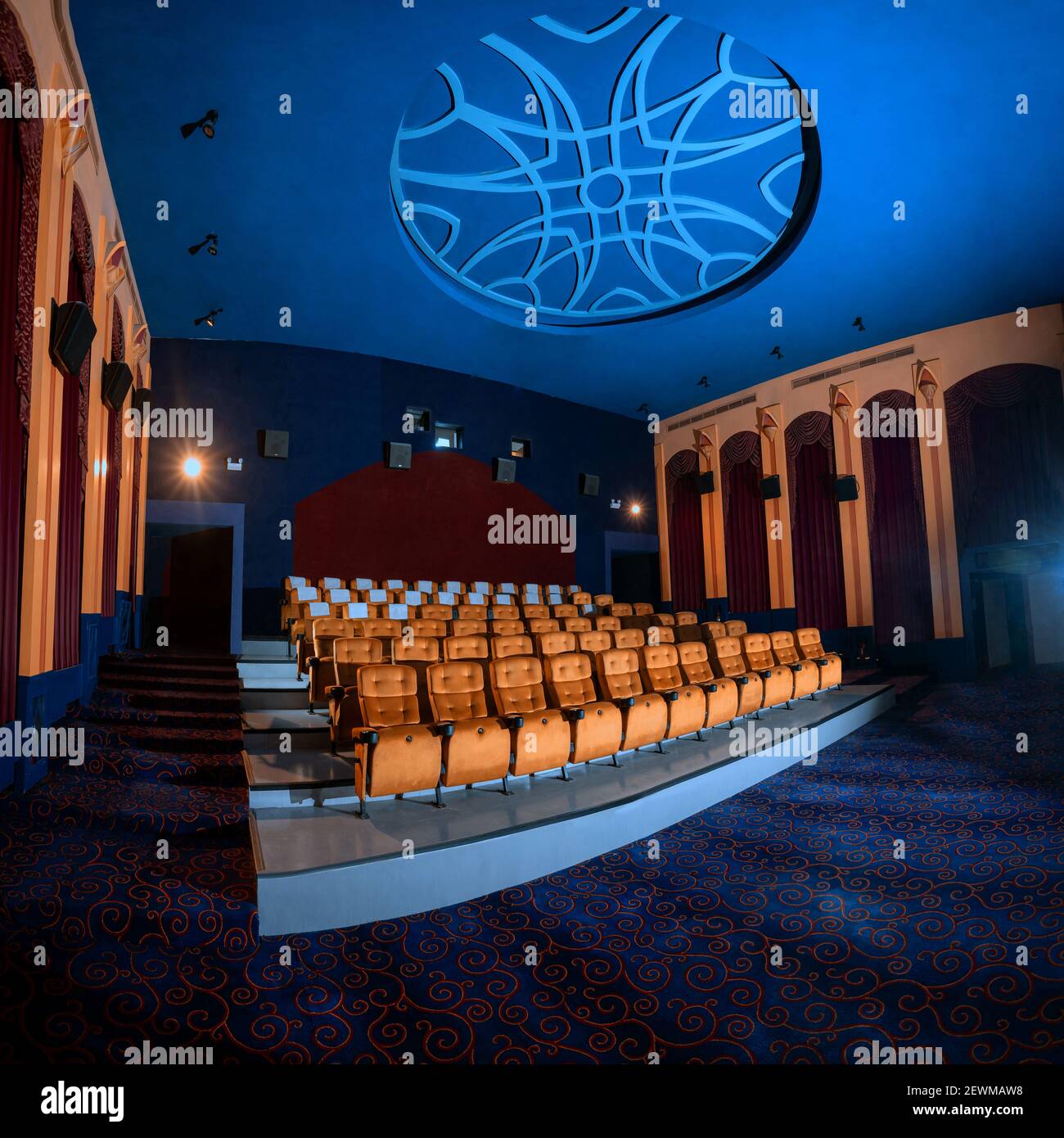 Large cinema theater interior with seat rows for audience to sit in