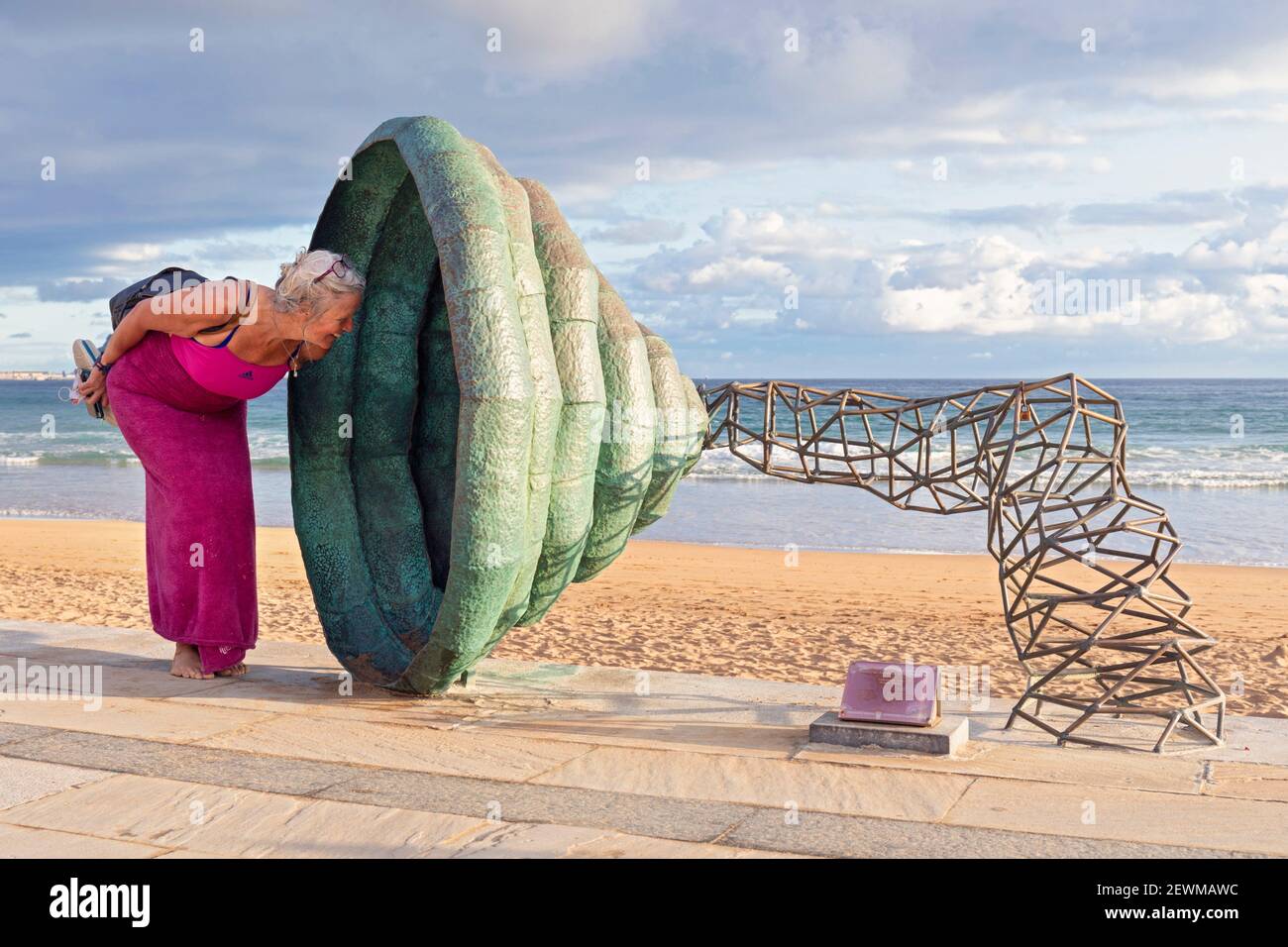 Europe, Spain, Gipuzkoa, Zarautz Beach with Sculpture shaped like a horn being investigated by a woman tourist. Stock Photo