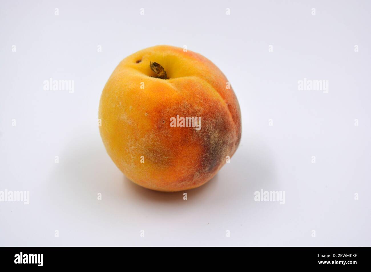 Tasty and useful fresh fruits, ripe red and orange peaches with a terry white skurt are located on a white background. Stock Photo