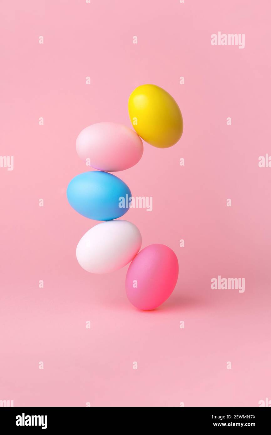 colorful easter eggs balancing over pink background Stock Photo