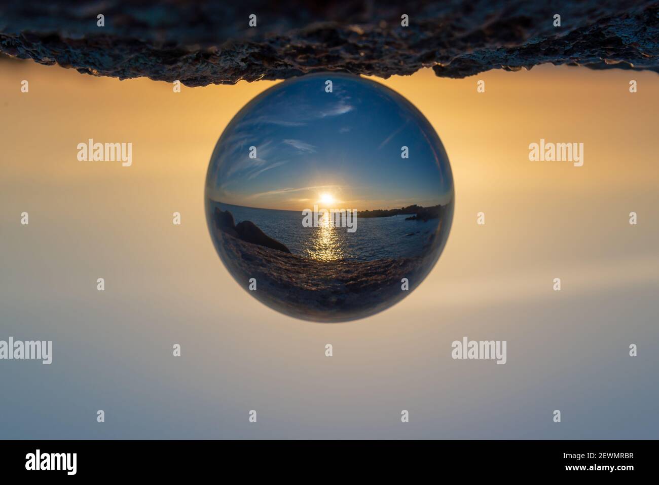 Sunset at the ocean seen through a crystal ball Stock Photo - Alamy