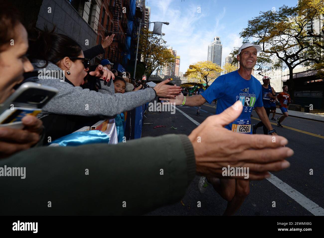 A runner gives highfives to onlookers as he exits the Ed Koch 59th(02)