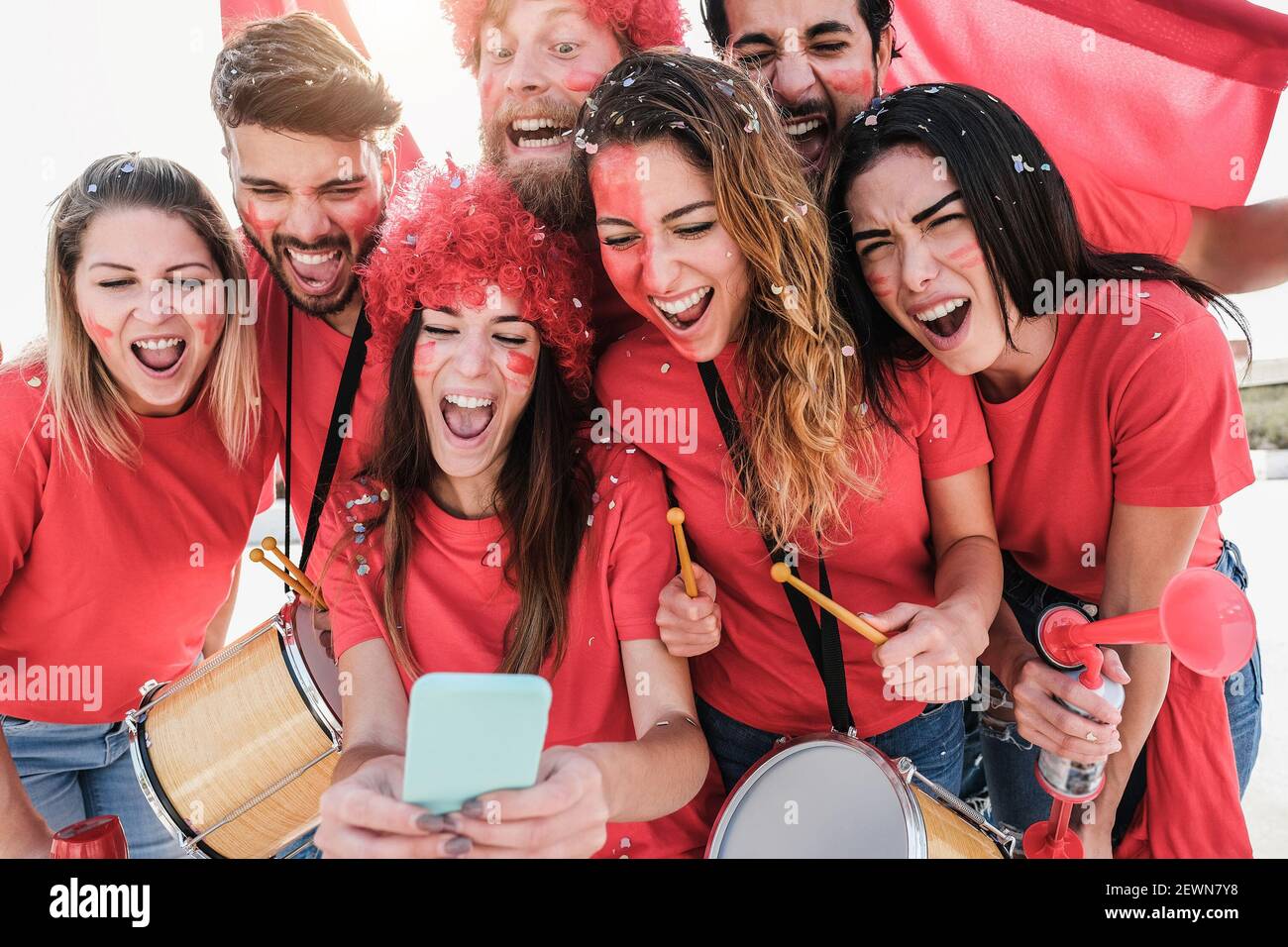 Happy sport supporters watching football on mobile phone - Focus on faces Stock Photo