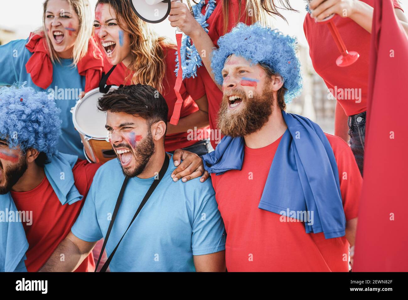 Crazy sport fans playing drums and screaming while supporting their