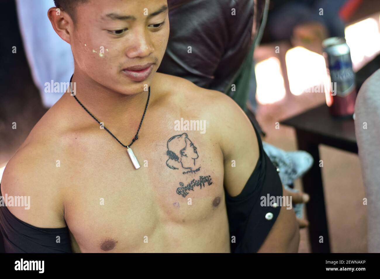 Myanmar, Nyaung Shwe,02 March 2021, : A young man wears a tattooed portrait of Aung San Suu Kyi, the ousted head of Myanmar's government, on his chest. In Myanmar, supporters of the