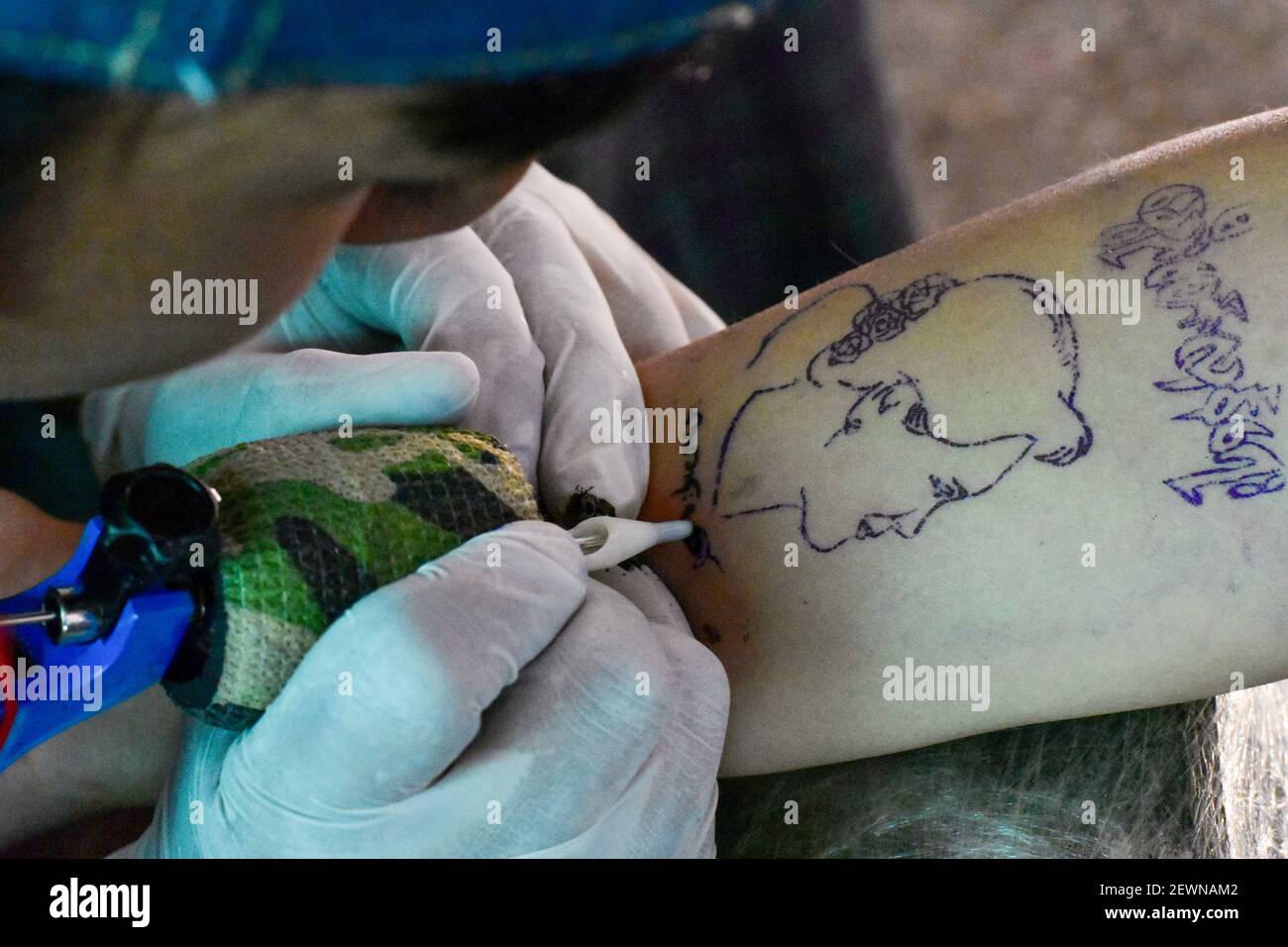 Myanmar, Nyaung Shwe,02 March 2021, : A tattoo artist works on a portrait of Aung San Suu Kyi, ousted head of government of Myanmar. In Myanmar, supporters of the ousted head of Myanmar, Nyaung Shwe,02 March 2021, : A tattoo artist works on a portrait of Aung San Suu Kyi, ousted head of government of Myanmar. In Myanmar, supporters of the ousted head of