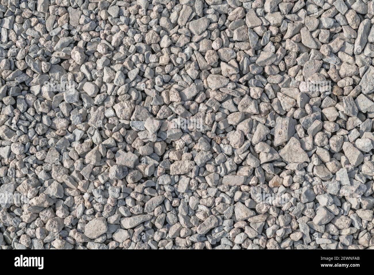 Compacted stone hardcore surface. For rough bumpy surface, fall on stony ground, broken, fragmented, gravel path, leave no stone unturned. Stock Photo