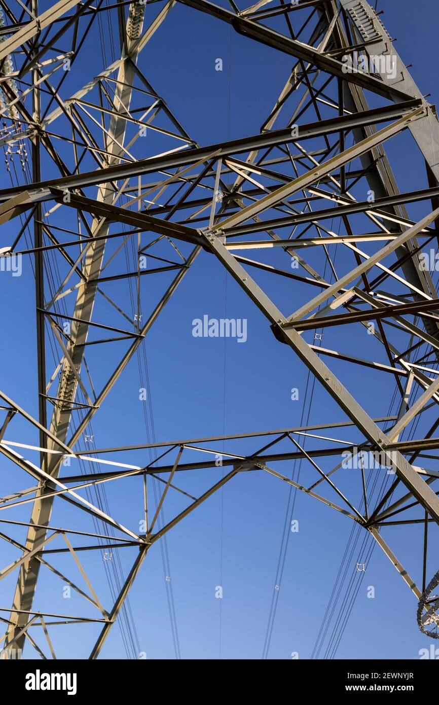 Electricity pylon and cables against a blue sky Stock Photo