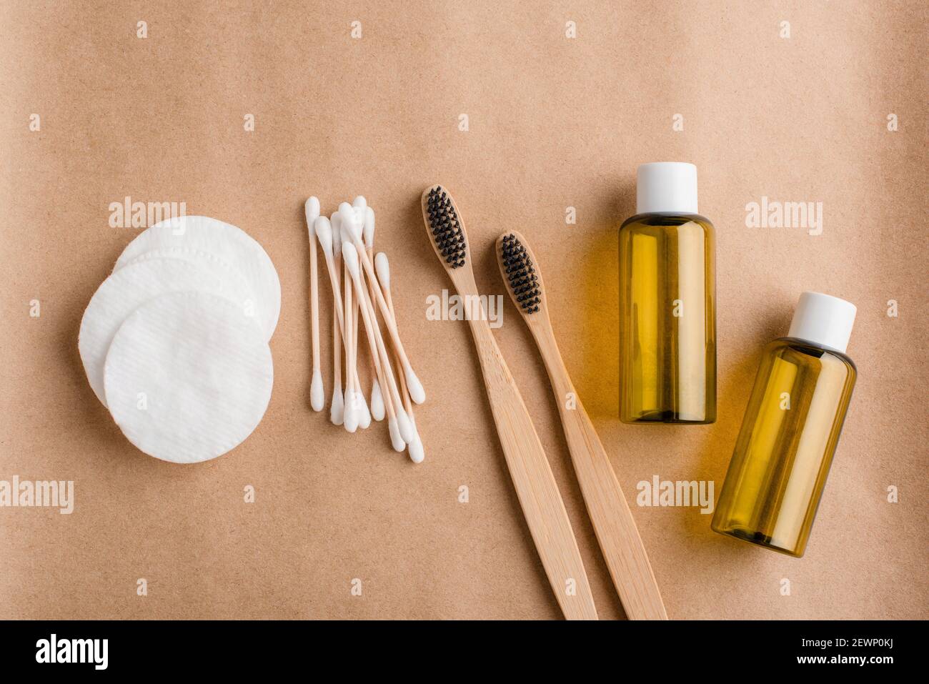 Eco friendly cosmetology and medical cleansing accessories. Cotton pads, bamboo ear sticks, oil essence pots and charcoal toothbrushes on beige backgr Stock Photo