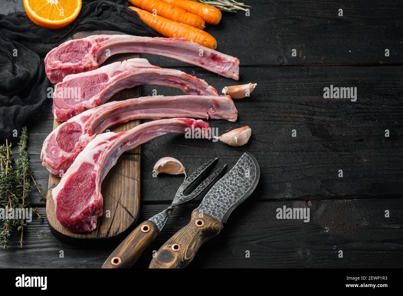 Frenched raw fatty lamb chops set, with ingredients carrot orange