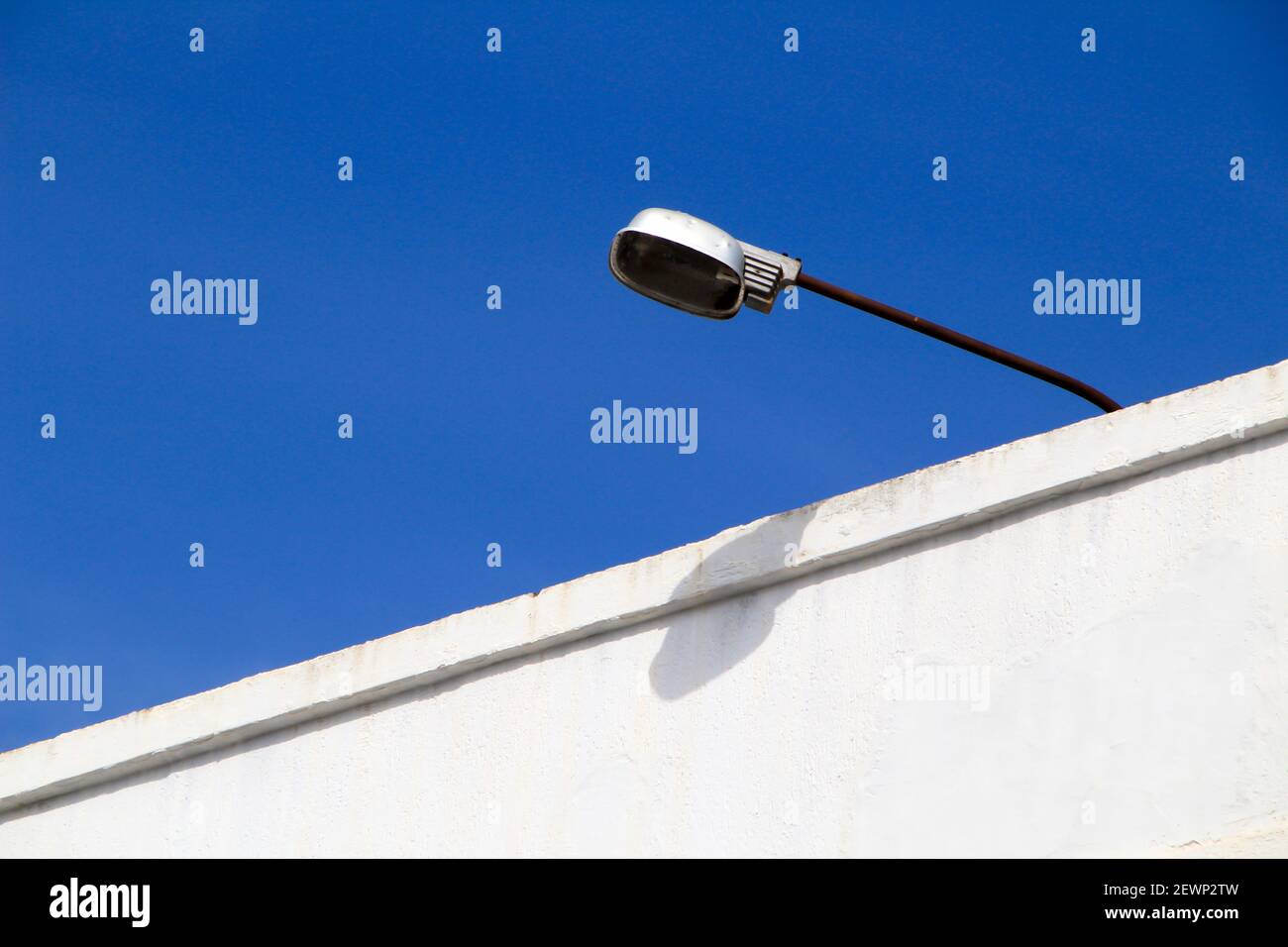 Vintage street lamp on white facade and blue sky Stock Photo